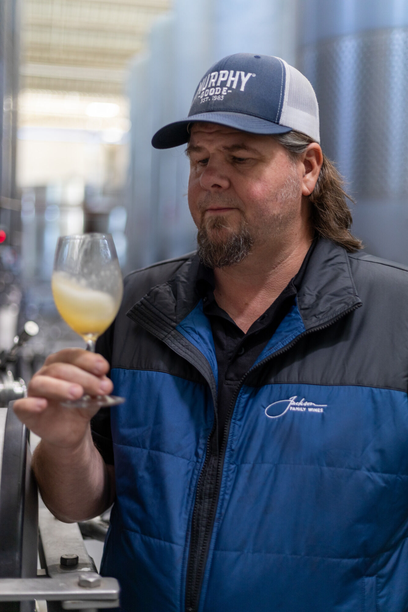 Murphy-Goode Winemaker, Dave Ready JR., standing in barrel room with a glass of wine.